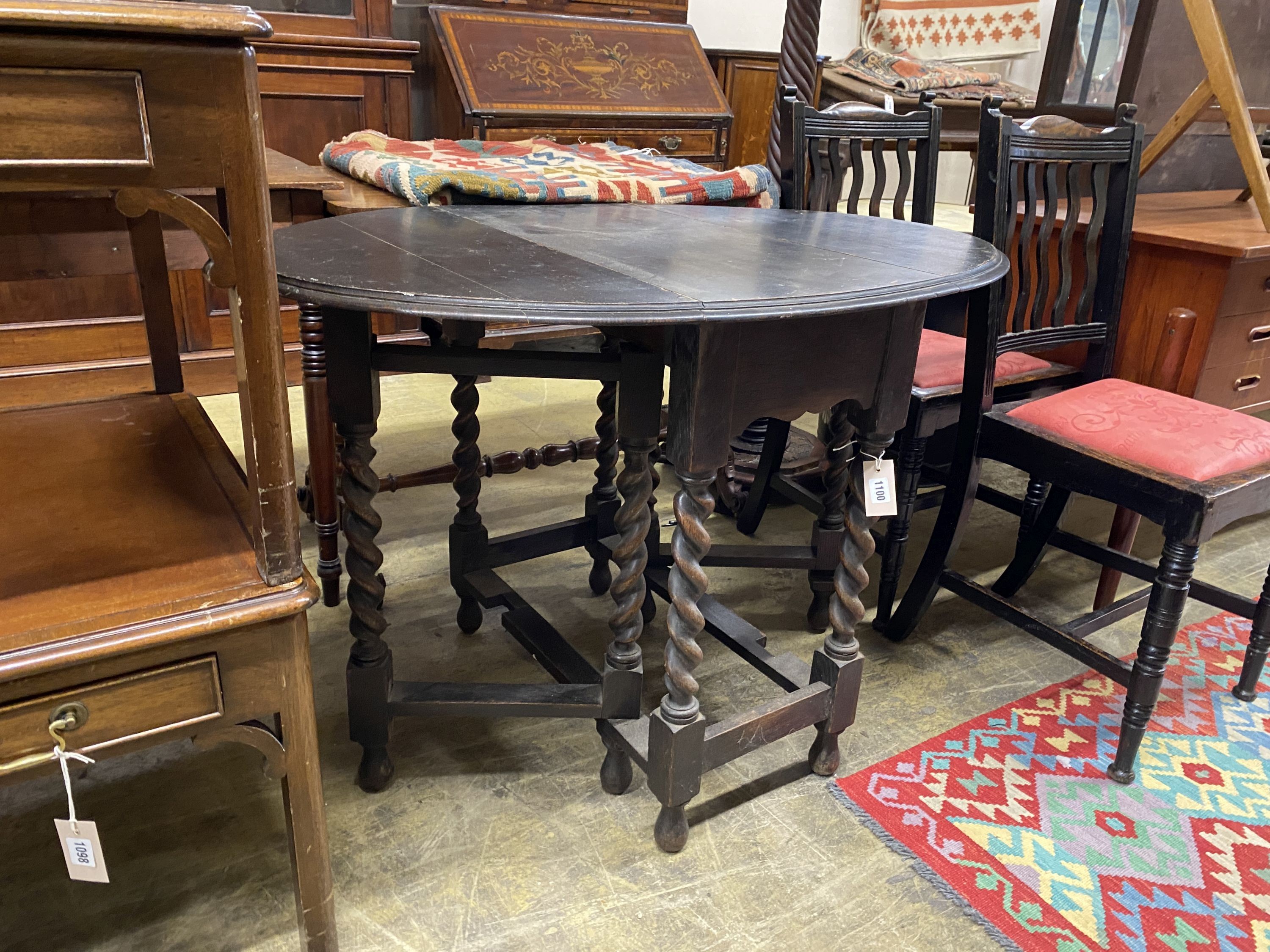 An early 20th century oak oval gateleg table, 106cm extended, width 74cm, height 74cm together with two oak dining chairs